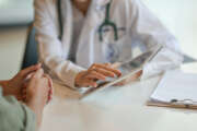 Shot of a doctor showing a patient some information on a digital tablet