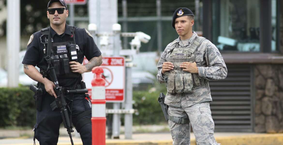 Security stands guard outside the main gate at Joint Base Pearl Harbor-Hickam, in Hawaii, Wednesday, Dec. 4, 2019. A shooting at Pearl Harbor Naval Shipyard in Hawaii left at least one person injured Wednesday, military and hospital officials said. Joint Base Pearl Harbor-Hickam spokesman Charles Anthony confirmed that there was an active shooting at Pearl Harbor Naval Shipyard. (AP Photo/Caleb Jones)