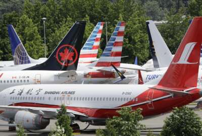 FILE - In this  Thursday, June 27, 2019 file photo, dozens of grounded Boeing 737 MAX airplanes crowd a parking area adjacent to Boeing Field in Seattle. Safety regulators want to fine Boeing nearly $4 million, saying that the company installed critical wing parts on 133 planes even though it knew the parts were faulty. The Federal Aviation Administration announced the proposed civil penalty on Friday, Dec. 6, 2019. (AP Photo/Elaine Thompson, File)