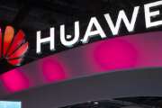 In this Oct. 31, 2019, photo, attendees walk past a display for 5G services from Chinese technology firm Huawei at the PT Expo in Beijing. Chinese tech giant Huawei is asking a U.S. federal court to throw out a rule that bars rural phone carriers from using government money to purchase its equipment on security grounds, announced Thursday, Dec. 5, 2019. (AP Photo/Mark Schiefelbein)