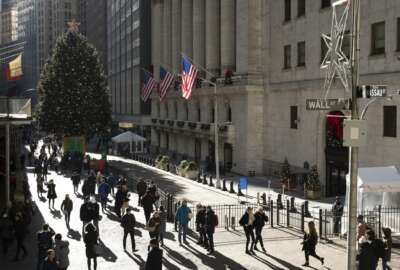 People walk by the New York Stock Exchange, Tuesday, Dec. 3, 2019. Stocks fell broadly Tuesday after President Donald Trump cast doubt over the potential for a trade deal with China this year and threatened to impose tariffs on French goods. (AP Photo/Mark Lennihan)