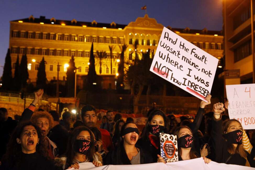 Protesters chant placards during a demonstration to protest sexual harassment and bullying and demanding rights, in front of the government house in downtown Beirut, Lebanon, Saturday, Dec. 7, 2019. Scores of women marched through the streets to protest sexual harassment and bullying and demanding rights including the passing of citizenship to children of Lebanese women married to foreigners. (AP Photo/Bilal Hussein)