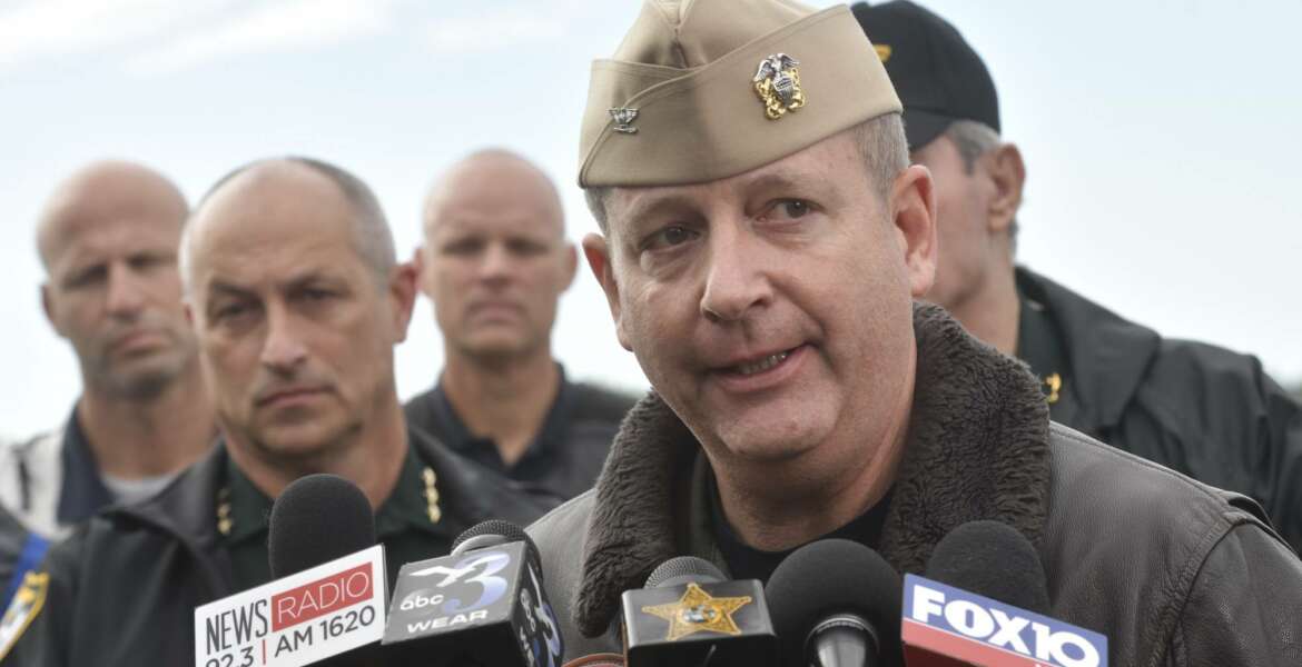 Navy Capt. Tim Kinsella briefs members of the media following a shooting at the Naval Air Station in Pensacola, Fla., Friday, Dec. 6, 2019. The US Navy is confirming that a shooter is dead and several injured after gunfire at the Naval Air Station in Pensacola. (Tony Giberson/Pensacola News Journal via AP)