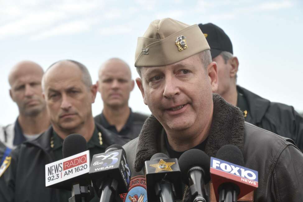 Navy Capt. Tim Kinsella briefs members of the media following a shooting at the Naval Air Station in Pensacola, Fla., Friday, Dec. 6, 2019. The US Navy is confirming that a shooter is dead and several injured after gunfire at the Naval Air Station in Pensacola. (Tony Giberson/Pensacola News Journal via AP)