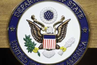 FILE - This Jan. 25, 2010, file photo, shows the United States Department of State seal on a podium at the State Department in Washington.  Two organizations of documentary filmmakers filed a federal lawsuit Thursday arguing that new rules requiring U.S. visa applicants to register their social media handles are making them fearful of publicly speaking their minds.  State Department rules took effect in May and apply to more than 14 million applicants each year, requiring them to register all their social media handles from the past five years on about 20 different online platforms. (AP Photo/Alex Brandon, File)