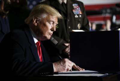 President Donald Trump signs the National Defense Authorization Act for Fiscal Year 2020 at Andrews Air Force Base, Md., Friday, Dec. 20, 2019. (AP Photo/Andrew Harnik)