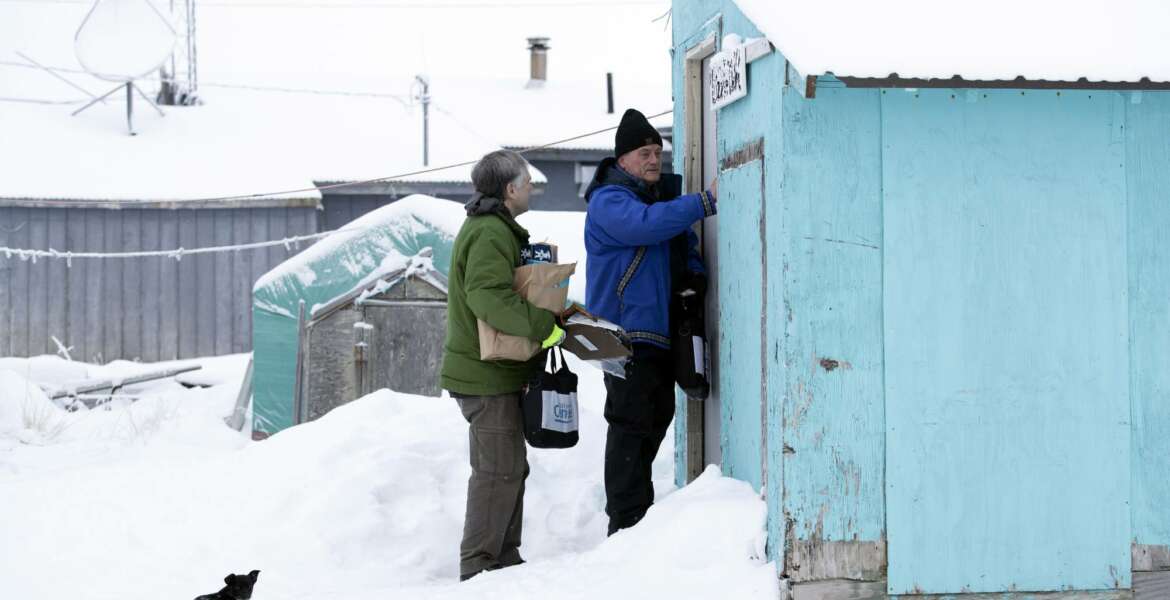 Census bureau director Steven Dillingham, right, knocks on the door alongside Census worker Tim Metzger as they arrive to conduct the first enumeration of the 2020 Census Tuesday, Jan. 21, 2020, in Toksook Bay, Alaska. (AP Photo/Gregory Bull)