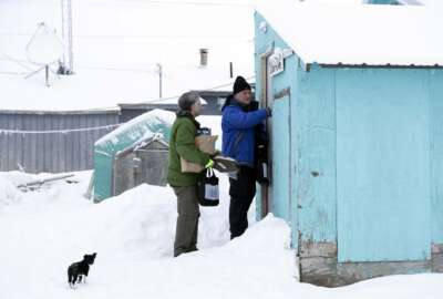 Census bureau director Steven Dillingham, right, knocks on the door alongside Census worker Tim Metzger as they arrive to conduct the first enumeration of the 2020 Census Tuesday, Jan. 21, 2020, in Toksook Bay, Alaska. (AP Photo/Gregory Bull)
