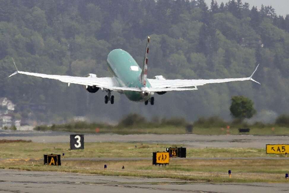 FILE - In this May 8, 2019, file photo a Boeing 737 MAX 8, being built for American Airlines, is partially obscured by the engine wash as it takes-off on a test flight in Renton, Wash. A government committee reviewing how the Federal Aviation Administration certifies new passenger planes for flight has determined that the system is safe and effective but small changes need to be made. The committee was appointed by Transportation Secretary Elaine Chao in April after two deadly crashes involving Boeing's 737 Max. (AP Photo/Elaine Thompson, File)