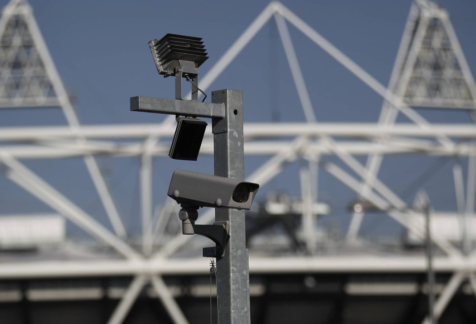 FILE - In this file photo dated Wednesday, March 28, 2012, a security cctv camera is seen by the Olympic Stadium at the Olympic Park in London.  The South Wales police deployed facial recognition surveillance equipment on Sunday Jan. 12, 2020, in a test to monitor crowds arriving for a weekend soccer match in real-time, that is prompting public debate about possible aggressive uses of facial recognition in Western democracies, raising questions about human rights and how the technology may enter people's daily lives in the future.  (AP Photo/Sang Tan, FILE)