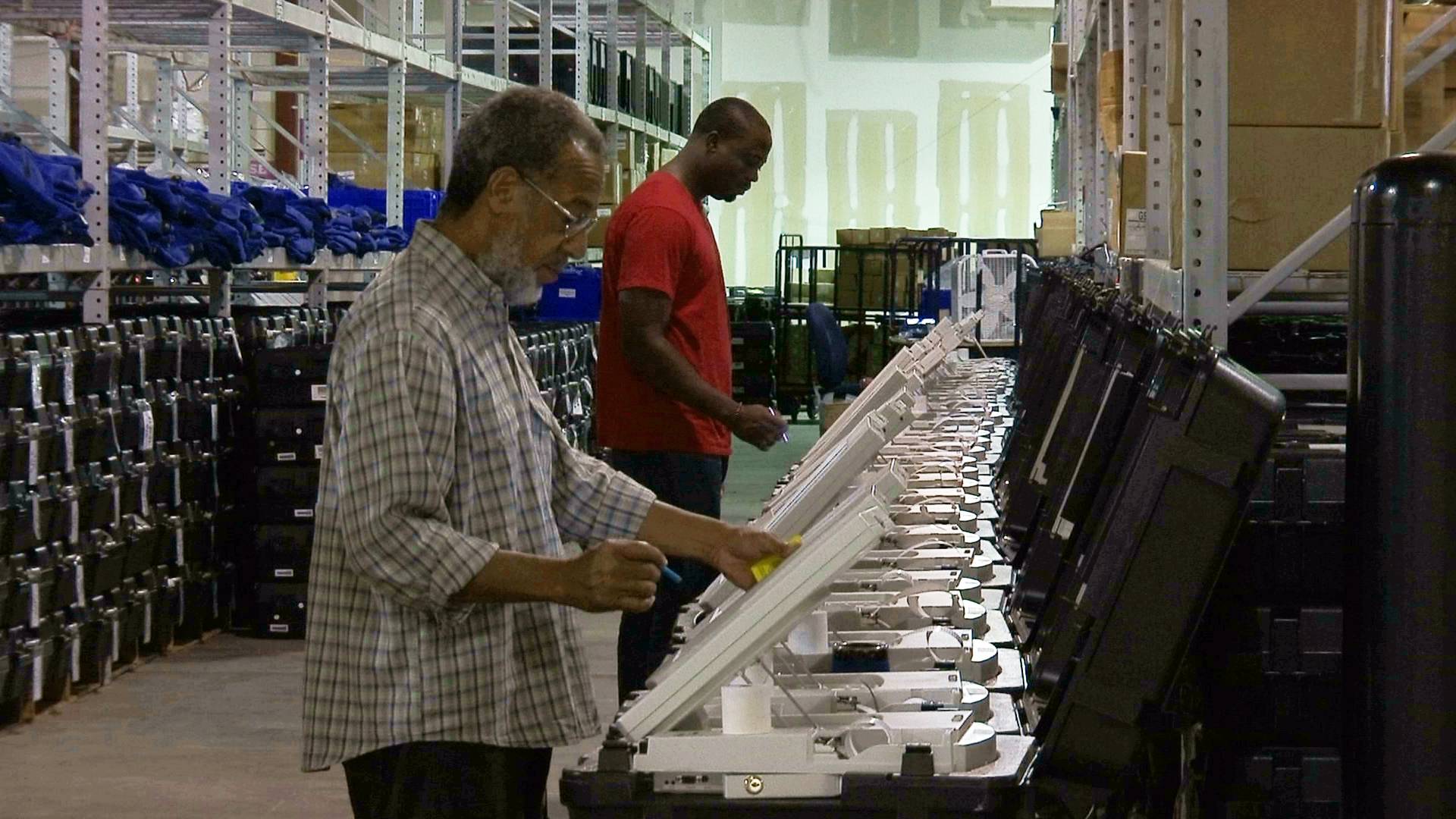 FILE - In this Sept. 22, 2016, file photo, employees of the Fulton County Election Preparation Center in Atlanta test electronic voting machines. A computer security expert says he found that an election server central to a legal battle over the integrity of Georgia elections showed signs of tampering. The server was left exposed to the open internet for at least six months, a problem discovered in August 2016. (AP Photo/Alex Sanz, File)