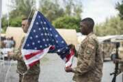 In this photo taken Aug. 26, 2019 and released by the U.S. Air Force, U.S. Air Force Staff Sgt. Sidney Dellinger, 475th Expeditionary Air Base Squadron materiel management journeyman, and Staff Sgt. Corey Smith, 475th EABS heating, ventilation, and air conditioning non-commissioned officer in charge, perform flag detail during a ceremony signifying the change from tactical to enduring operations at Camp Simba, Manda Bay, Kenya. The al-Shabab extremist group said Sunday, Jan. 5, 2020 that it has attacked the Camp Simba military base used by U.S. and Kenyan troops in coastal Kenya, while Kenya's military says the attempted pre-dawn breach was repulsed and at least four attackers were killed. (Staff Sgt. Lexie West/U.S. Air Force via AP)