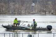 FILE- In this March 16, 2019 file photo, surveyors with the USGS take measurements of the Missouri River in Omaha, Neb., as the river overflows its banks. Nebraska, Iowa, Kansas and Missouri are joining forces for a study that will look for ways the states can limit flooding along the Missouri River and give them information about how wetter weather patterns could require changes to the federal government's management of the basin's reservoirs. The states are pooling their money to pay for half of a $400,000 study with the U.S. Army Corps of Engineers to measure how much water flows down the Missouri River. (AP Photo/Nati Harnik)