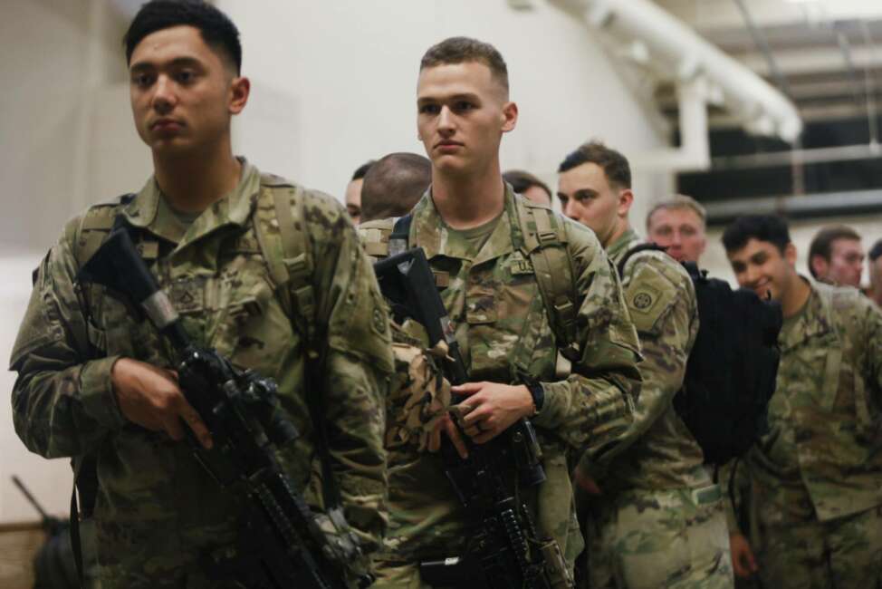 This photo provided by the U.S. Army, paratroopers assigned to 1st Brigade Combat Team, 82nd Airborne Division walk as they prepare equipment and load aircraft bound for the U.S. Central Command area of operations from Fort Bragg, N.C., Saturday, Jan. 4, 2020. (Spc. Hubert Delany III/U.S. Army via AP)