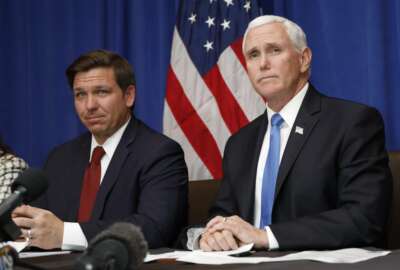 Vice President Mike Pence, right, and Florida Gov. Ron DeSantis take questions during a Florida Coronavirus Response Meeting, at the West Palm Beach International Airport, Friday, Feb. 28, 2020, in West Palm Beach, Fla. (AP Photo/Terry Renna)
