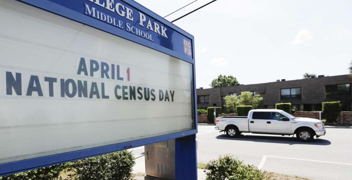 In this Tuesday, March 24, 2020 photo, a sign at a middle school in Orlando, Fla., reminds residents that April First is census day. The coronavirus has waylaid efforts to get as many people as possible to take part in the census. (AP Photo/John Raoux)