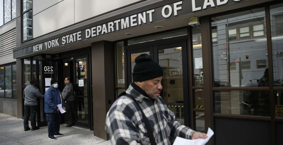 FILE - In this March 18, 2020 file photo, visitors to the Department of Labor are turned away at the door by personnel due to closures over coronavirus concerns in New York. A record-high number of people applied for unemployment benefits last week as layoffs engulfed the United States in the face of a near-total economic shutdown caused by the coronavirus. The surge in weekly applications for benefits far exceeded the previous record set in 1982.  (AP Photo/John Minchillo, File)