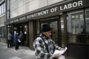 FILE - In this March 18, 2020 file photo, visitors to the Department of Labor are turned away at the door by personnel due to closures over coronavirus concerns in New York. A record-high number of people applied for unemployment benefits last week as layoffs engulfed the United States in the face of a near-total economic shutdown caused by the coronavirus. The surge in weekly applications for benefits far exceeded the previous record set in 1982.  (AP Photo/John Minchillo, File)