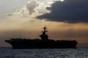 FILE - In this April 13, 2018, file photo the USS Theodore Roosevelt aircraft carrier is anchored off Manila Bay west of Manila, Philippines. The captain of the U.S. Navy aircraft carrier facing a growing outbreak of the coronavirus is asking for permission to isolate the bulk of his roughly 5,000 crew members on shore, which would take the warship out of duty in an effort to save lives. The ship is docked in Guam (AP Photo/Bullit Marquez, File)