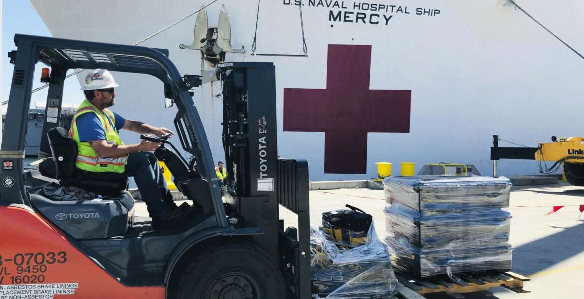 Steve King, a Naval Facilities Engineering Command Southwest forklift driver, prepares to deliver pallets during a supply load aboard the Military Sealift Command hospital ship USNS Mercy (T-AH 19) at Naval Base San Diego, adjacent to San Diego, Calif., Saturday, March 21, 2020. Mercy is preparing to deploy in support of the nation's COVID-19 response efforts and will serve as a referral hospital for non-COVID-19 patients currently admitted to shore-based hospitals. (Senior Chief Mass Communication Specialist Mike Jones/U.S. Navy via AP)