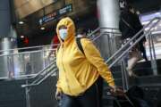 A commuter wears a face mask in the New York City transit system, Monday, March 9, 2020, in New York. New York continued grappling Monday with the new coronavirus, as case numbers, school closings and other consequences grew. (AP Photo/John Minchillo)