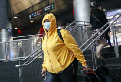 A commuter wears a face mask in the New York City transit system, Monday, March 9, 2020, in New York. New York continued grappling Monday with the new coronavirus, as case numbers, school closings and other consequences grew. (AP Photo/John Minchillo)