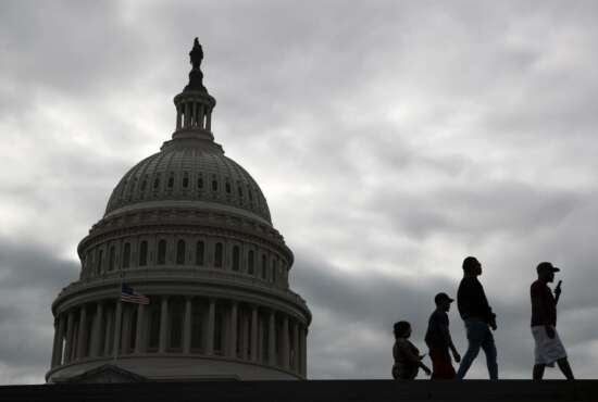 Visitors walk past the U.S. Capitol dome on Capitol Hill in Washington, Thursday, March 12, 2020. Congress is shutting the Capitol and all House and Senate office buildings to the public until April in reaction to the spread of the coronavirus outbreak. (AP Photo/Patrick Semansky)