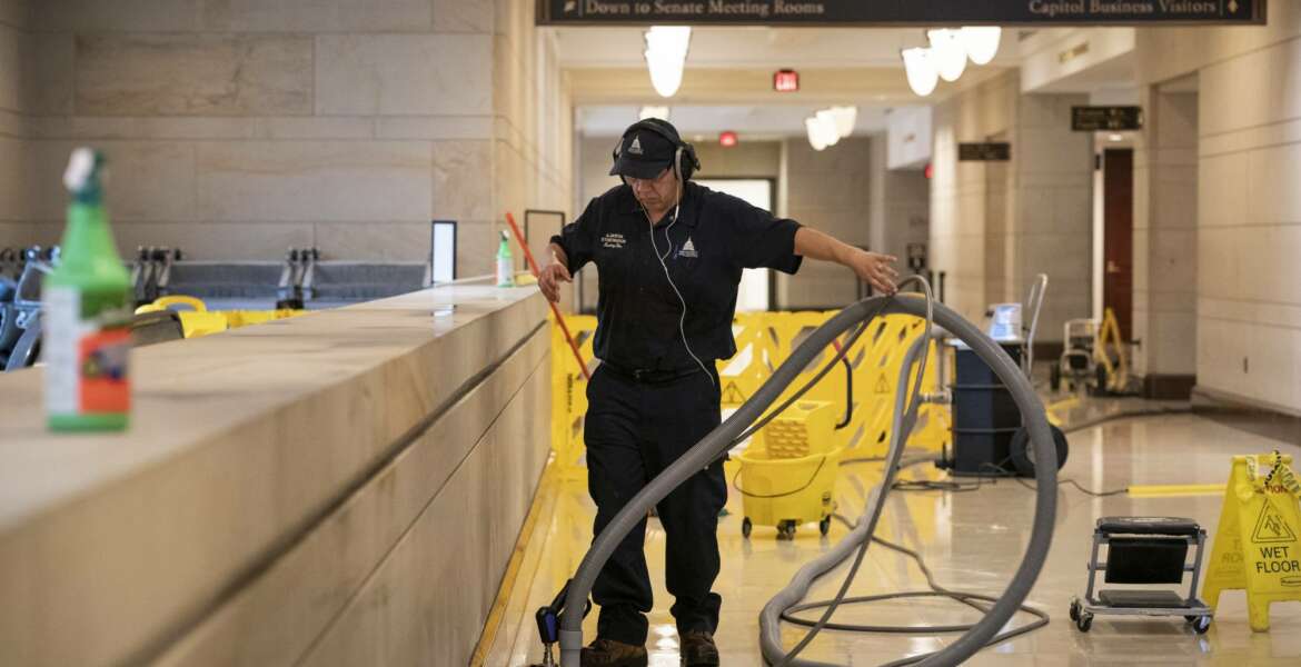 With the Capitol shut down to tourists, a workman performs a routine cleaning of surfaces in the Capitol Visitor Center, early Friday, March 13, 2020, in Washington. (AP Photo/J. Scott Applewhite)