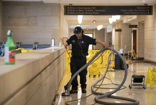 With the Capitol shut down to tourists, a workman performs a routine cleaning of surfaces in the Capitol Visitor Center, early Friday, March 13, 2020, in Washington. (AP Photo/J. Scott Applewhite)