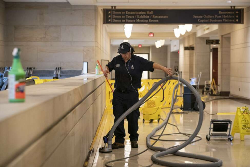 With the Capitol shut down to tourists, a workman performs a routine cleaning of surfaces in the Capitol Visitor Center, early Friday, March 13, 2020, in Washington. (AP Photo/J. Scott Applewhite)