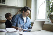 Father and son working on laptop. businessman working from home and watching child. spending time with kid. Young man working on computer. StartUp. Freelance concept. successful modern family.