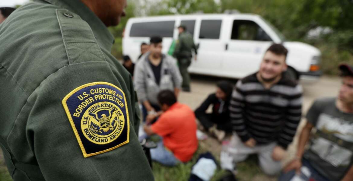 FILE - In this Thursday, March 14, 2019, file photo, a Border Patrol agent talks with a group suspected of having entered the U.S. illegally near McAllen, Texas. The Trump administration has quietly shut down the nation's asylum system for the first time in decades amid coronavirus concerns, largely because holding people in custody is considered too dangerous. (AP Photo/Eric Gay, File)