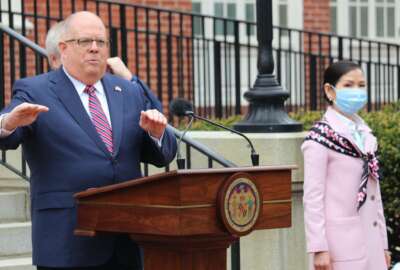 Maryland Gov. Larry Hogan speaks at a news conference on Monday, April 20, 2020 in Annapolis, Md., with his wife, Yumi Hogan, right, where the governor announced Maryland has received a shipment from a South Korean company to boost the state's ability to conduct tests for COVID-19 by 500,000. Hogan said he asked his wife, who is Korean, to help negotiate with Korean officials, on March 28, and that set in motion 22 days of vetting and negotiations to bring the large increase in testing capacity to Maryland. (AP Photo/Brian Witte)
