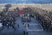 In this Dec. 15, 2019, photo U.S.Navy Capt. Brett Crozier, commanding officer of the aircraft carrier USS Theodore Roosevelt (CVN 71), addresses the crew during an all hands call on the ship's flight deck while conducting routine training in the Eastern Pacific Ocean. U.S. defense leaders are backing the Navy's decision to fire the ship captain who sought help for his coronavirus-stricken aircraft carrier, even as videos showed his sailors cheering him as he walked off the vessel. Videos went viral on social media Friday, April 3, 2020, showing hundreds of sailors gathered on the ship chanting and applauding Navy Capt. Brett Crozier as he walked down the ramp, turned, saluted, waved and got into a waiting car. (U.S. Navy Photo by Mass Communication Specialist Seaman Kaylianna Genier via AP)