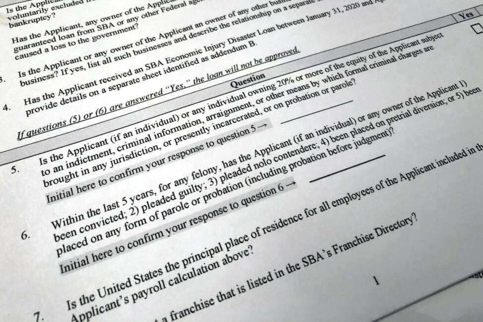 Shown is a portion of a Small Business Administration Paycheck Protection Program Borrower Application Form, Tuesday, April 21, 2020 in Washington. The Paycheck Protection was supposed to be a lifeline for small businesses, helping them stay afloat and keep their employees on the payroll during the coronavirus pandemic. But guidelines from the Small Business Administration say that businesses are ineligible if someone who owns at least 20 percent of the company is incarcerated, under indictment, on probation or parole or had been convicted of a felony within the last five years. Ineligible would-be applicants and advocates say the restrictions are a slap in the face for those who have served their time, especially from an administration that has trumpeted second chances. (AP Photo/Wayne Partlow)