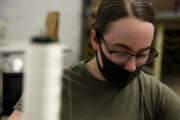 In this April 17, 2020 photo, a mask covers the face of a U.S. Army Fort Bragg soldier as she sews PPE. Her unit has already constructed thousands of masks since "Operation Dragon Mask" began last week on the North Carolina military installation. (AP Photo/Sarah Blake Morgan)