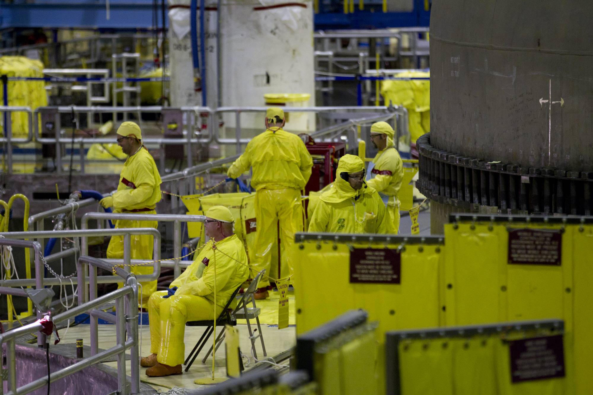 FILE - In this March 25, 2011, file photo, workers gather near the Unit 2 reactor which is undergoing re-fueling during a tour of the Browns Ferry nuclear plant in Athens, Ala. U.S. nuclear plants will be allowed to keep workers on longer shifts to deal with staffing problems in the coronavirus pandemic. Nuclear Regulatory Commission officials outlined the temporary shift extensions to nuclear power officials on Thursday, April 2, 2020. (AP Photo/Dave Martin, File)