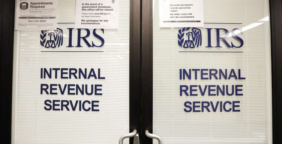 FILE - In this Jan. 16, 2019, file photo, doors at the Internal Revenue Service (IRS) in the Henry M. Jackson Federal Building are locked and covered with blinds as a sign posted advises that the office will be closed during the partial government shutdown in Seattle. Videos and reports claiming that you'll have to pay back the relief checks the federal government is sending to millions of Americans are false, federal agencies confirmed to The Associated Press. (AP Photo/Elaine Thompson, File)