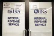 FILE - In this Jan. 16, 2019, file photo, doors at the Internal Revenue Service (IRS) in the Henry M. Jackson Federal Building are locked and covered with blinds as a sign posted advises that the office will be closed during the partial government shutdown in Seattle. Videos and reports claiming that you'll have to pay back the relief checks the federal government is sending to millions of Americans are false, federal agencies confirmed to The Associated Press. (AP Photo/Elaine Thompson, File)