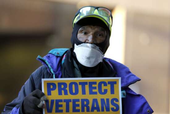Clarence Shields, an Army veteran, pickets with a small group of activists from the American Federation of Government Employees local 424 and the National Association of Government Employees local R3-19 during the coronavirus pandemic, outside the Baltimore VA Medical Center, Wednesday, April 22, 2020, in Baltimore. The Department of Veterans Affairs is struggling with shortages of workers at its health care facilities as it cares for veterans infected with the novel coronavirus. (AP Photo/Julio Cortez)