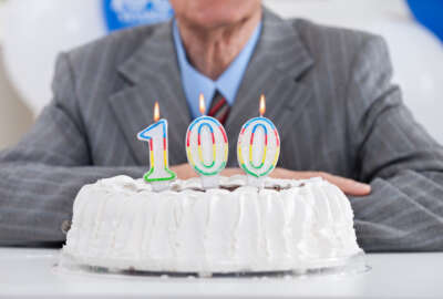 birthday cake with lit candles for a century, one hundredth birthday