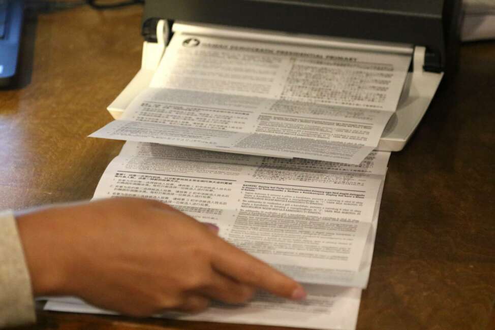 Democratic Party of Hawaii staff tabulate presidential primary ballots in Honolulu on Friday, May 22, 2020. The Democratic Party of Hawaii is scheduled Saturday to release the results of its party-run presidential primary which was delayed by more than a month due the coronavirus pandemic. The party expected most members to vote by mail and some to cast ballots at about 20 in-person polling sites. But concerns about the virus forced the party to cancel in-person voting and allow only mail ballots. (AP Photo/Caleb Jones)