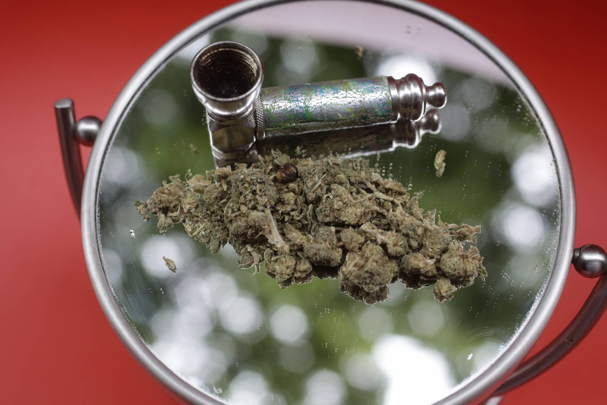 In this June 20, 2018 photo, marijuana and a pipe used to smoke it are displayed on a mirror in New York. In a law that went into effect on Sunday, May 10, 2020, New York City has barred many employers from making job applicants get tested for marijuana use. Supporters of the testing ban said job-seekers were unfairly being judged on private behavior, rather than professional ability. (AP Photo/Peter Morgan, File)