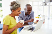 Mature African American Couple Using Laptop At Breakfast