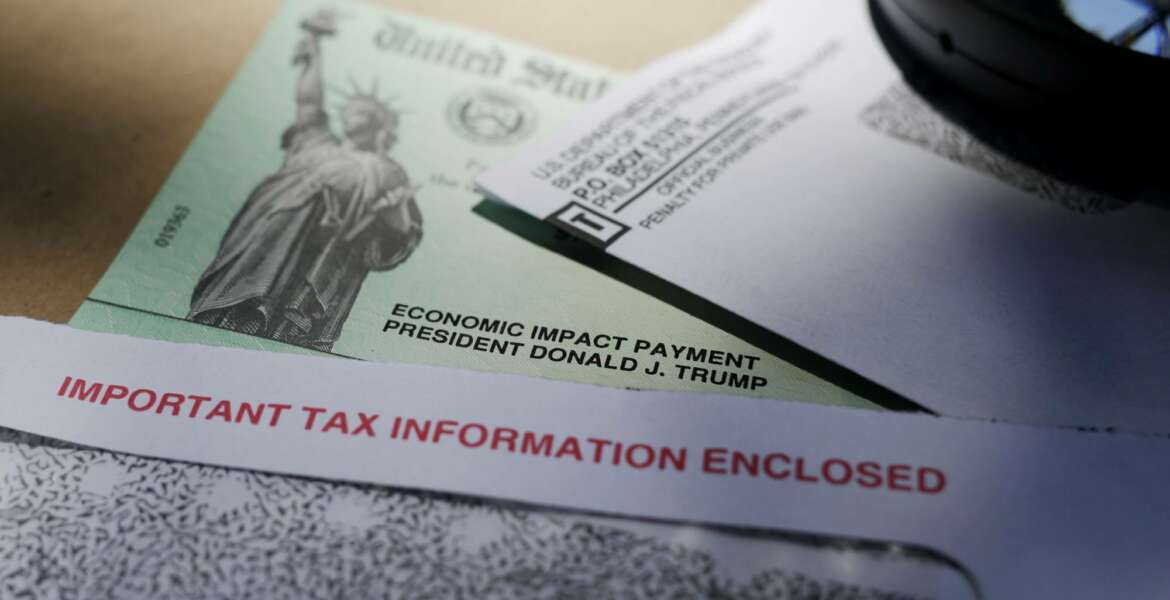 In this April 23, 2020, photo, President Donald Trump's name is seen on a stimulus check issued by the IRS to help combat the adverse economic effects of the COVID-19 outbreak, in San Antonio. The US government has distributed about 130 million economic impact payments to taxpayers in less than 30 days. The IRS anticipates sending more than 150 million payments as part of a massive coronavirus rescue package. The distribution has had some hiccups, including an overwhelmed website, payments to deceased taxpayers and money sent to inactive accounts. (AP Photo/Eric Gay)