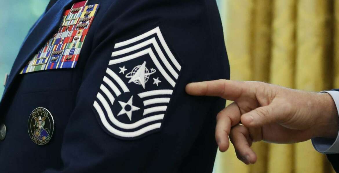Chief Master Sgt. Roger Towberman displays his insignia during a presentation of the United States Space Force flag in the Oval Office of the White House, Friday, May 15, 2020, in Washington. (AP Photo/Alex Brandon)