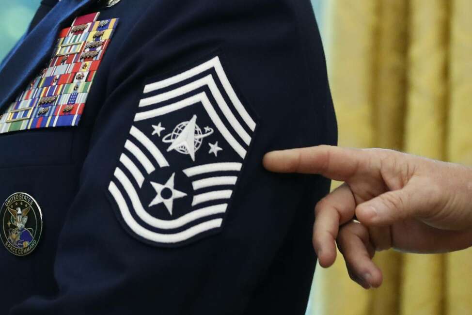 Chief Master Sgt. Roger Towberman displays his insignia during a presentation of the United States Space Force flag in the Oval Office of the White House, Friday, May 15, 2020, in Washington. (AP Photo/Alex Brandon)