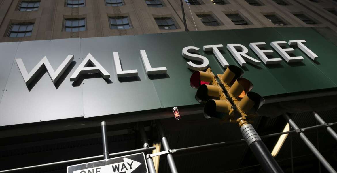 A sign for a Wall Street building is shown, Tuesday, June 16, 2020. Stocks are rising sharply in early trading on Wall Street after retail sales in the U.S. soared by a record 17.7% from April to May, double what economists were expecting and a welcome sign that spending is partially rebounding after the devastating coronavirus shutdowns.  (AP Photo/Mark Lennihan)
