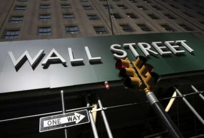 A sign for a Wall Street building is shown, Tuesday, June 16, 2020. Stocks are rising sharply in early trading on Wall Street after retail sales in the U.S. soared by a record 17.7% from April to May, double what economists were expecting and a welcome sign that spending is partially rebounding after the devastating coronavirus shutdowns.  (AP Photo/Mark Lennihan)