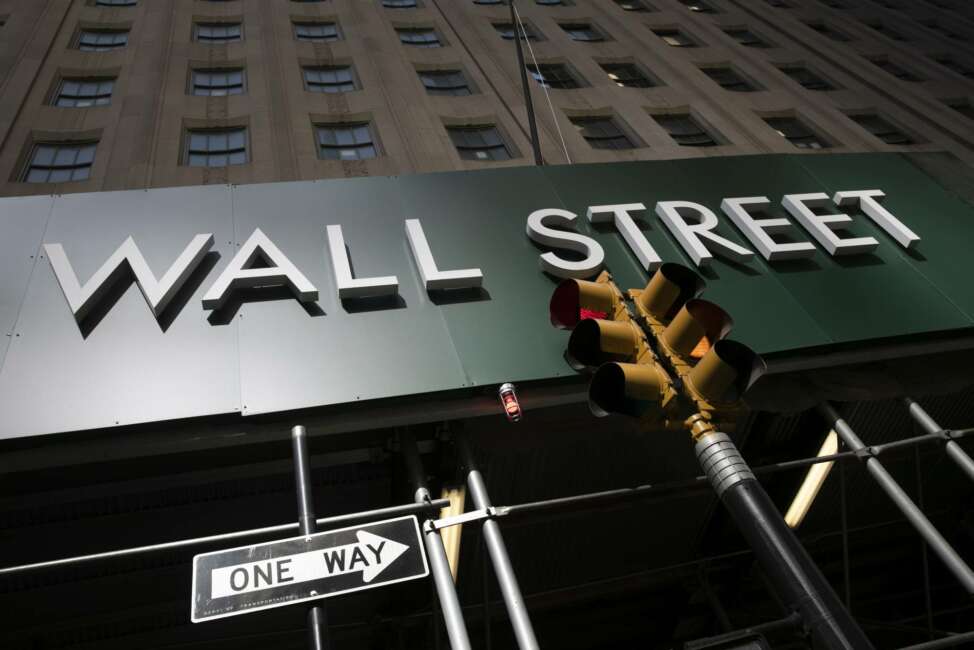 A sign for a Wall Street building is shown, Tuesday, June 16, 2020. Stocks are rising sharply in early trading on Wall Street after retail sales in the U.S. soared by a record 17.7% from April to May, double what economists were expecting and a welcome sign that spending is partially rebounding after the devastating coronavirus shutdowns.  (AP Photo/Mark Lennihan)